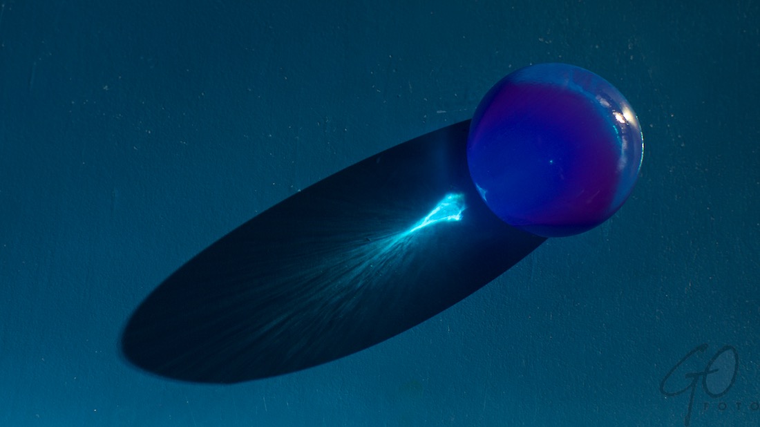 Polymeer en meer. Foto van een gekleurde waterbal op een blauwe ondergrond.