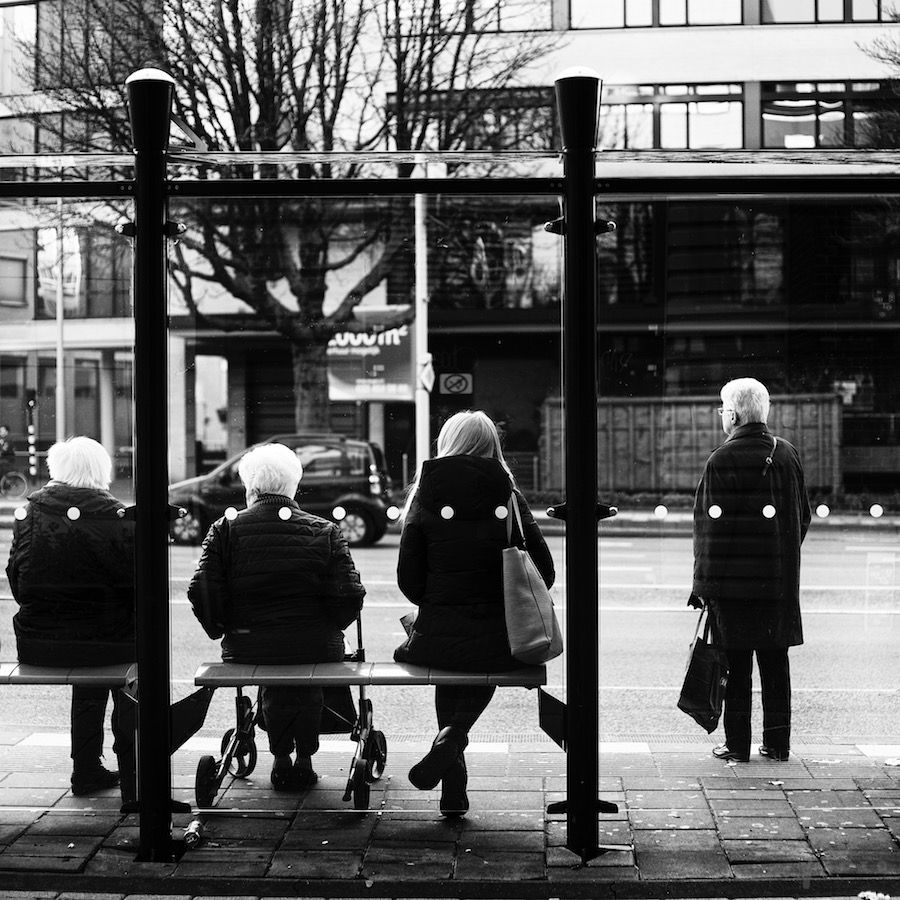 Blondies bij de bus. Foto van vier vrouwen bij een bushalte.