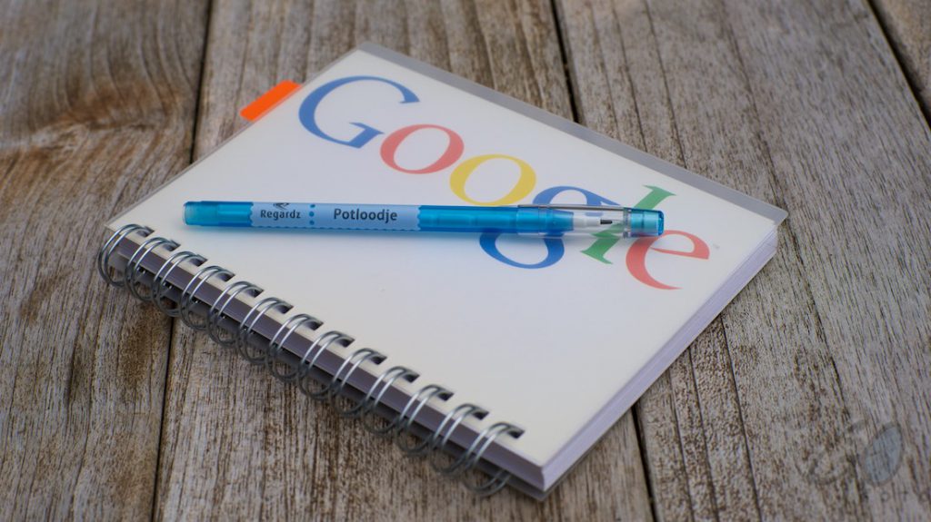 Tekstschrijvers en lezers willen structuur in een verhaal. Foto van notitieblok van Google met blauwe pen.