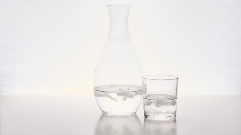 Karaf en glas water in hard tegenlicht