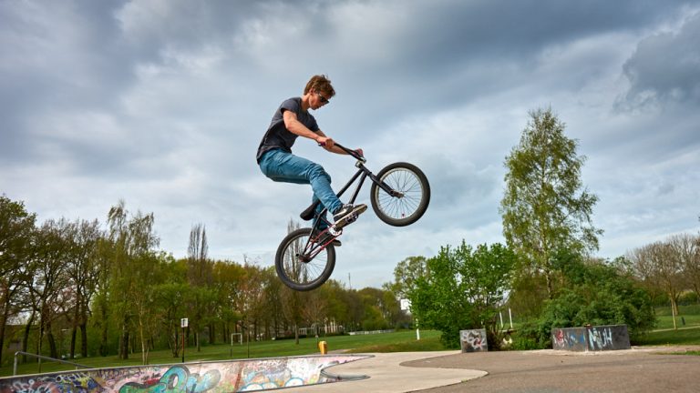 Jongen springt hoog in de lucht met een fiets