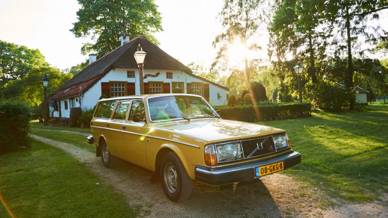 Oude, gele Volvo voor romantisch boerderijtje