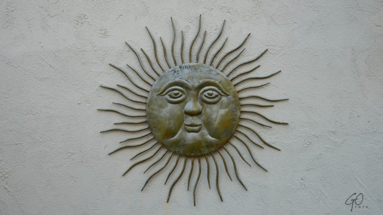 Beeld van een zon aan de muur