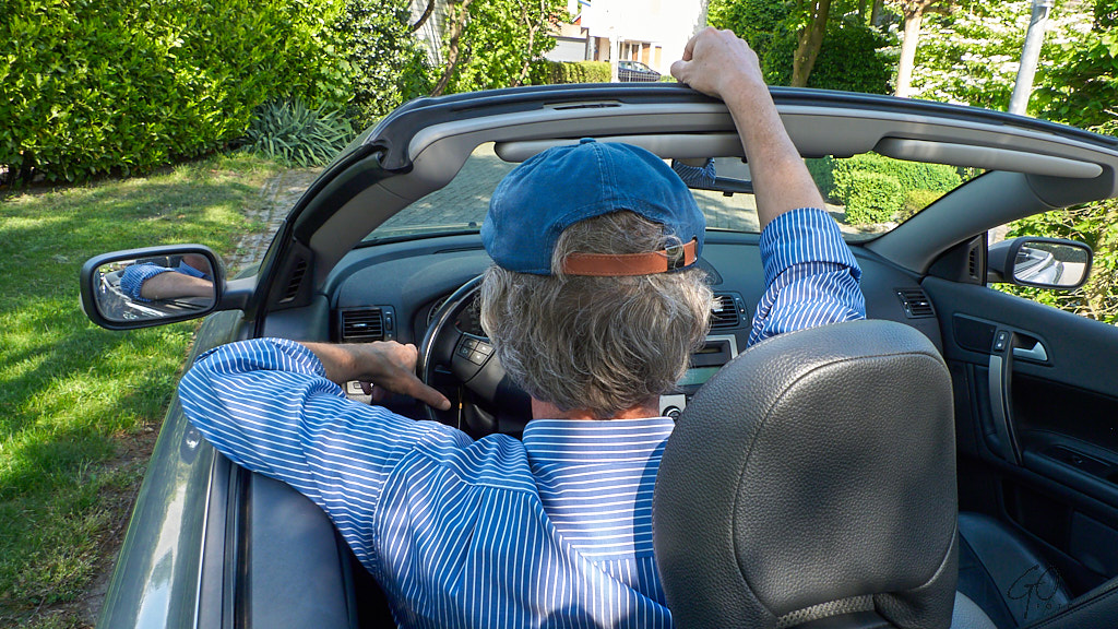 Man in cabrio van achteren gefotografeerd
