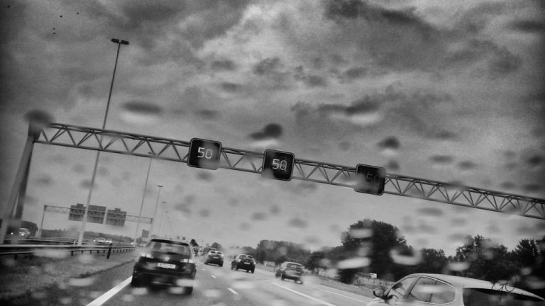 Regenachtig snelweg met op matrixborden 50km.