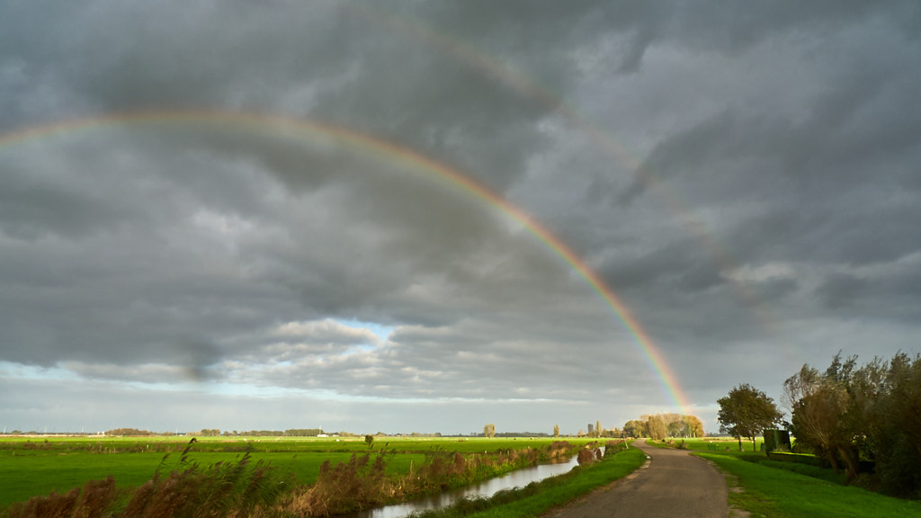 Dubbele regenboog boven polderlandschap